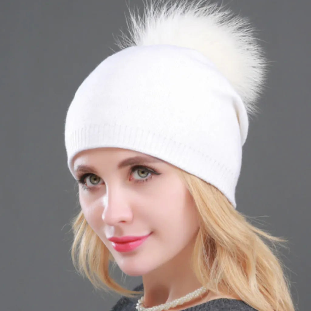 Bonnet casual chic en laine mélangée, cachemire, coton et acrylique porté sur la tête d'une femme blonde souriante.