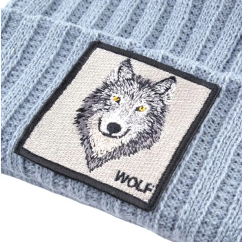 Vu en gros plan de l'écusson carré Wolf d'un bonnet Loup en laine acrylique de couleur gris-bleu