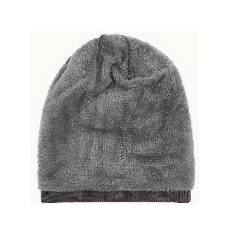 Vue du bonnet Osiris à l'envers, posé à plat sur un fond blanc, on aperçois sa doublure douce et chaude en peluche en fibre de polyester non irritable  - coloris gris