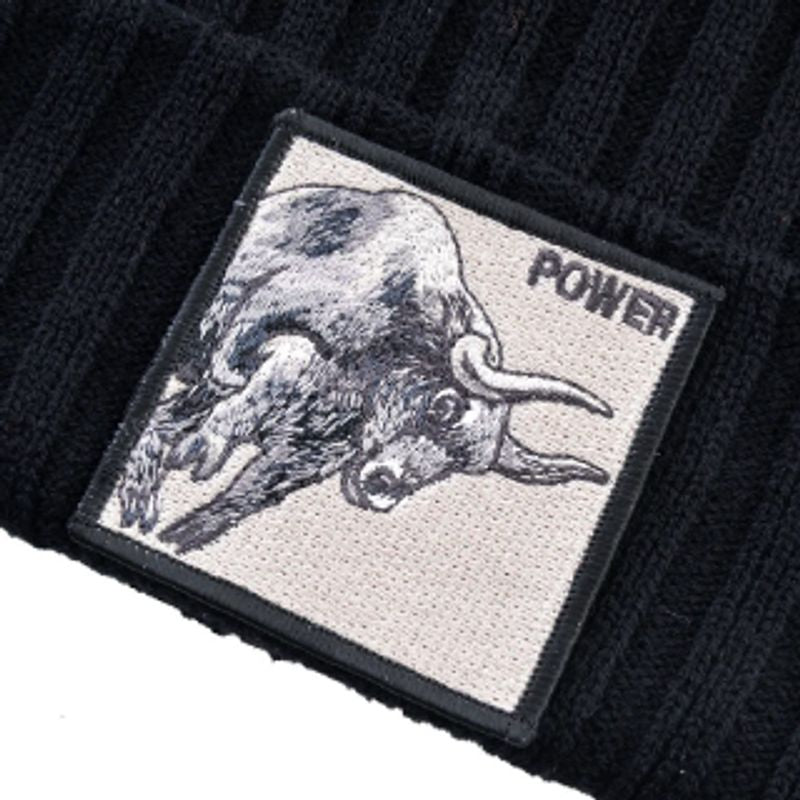 Gros plan sur l'écusson POWER brodé du bonnet Taureau en laine acrylique noire - couvre-chef chaud, design unisexe