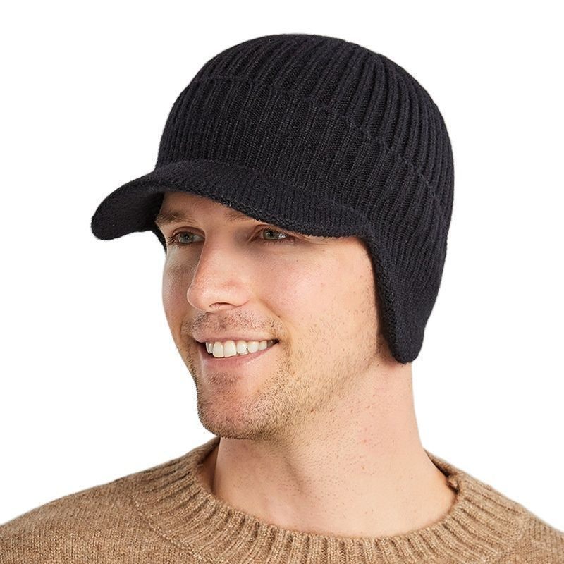 Bonnet à visière Sapporo porté sur une tête d'un jeune homme souriant, ses oreilles sont recouvertes de cache-oreilles intégrés en laine acrylique de couleur noire
