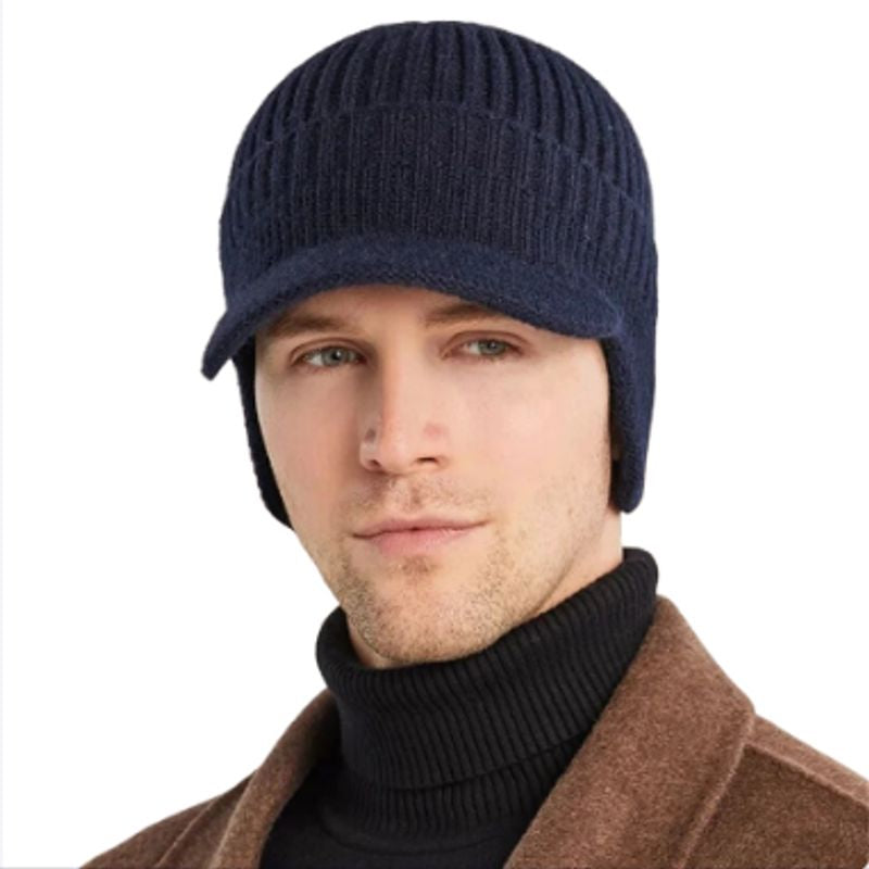 Bonnet à visière Sapporo avec cache-oreilles sur la tête d'un jeune homme habillé chaudement - bonnet tricoté en laine acrylique - doublure peluche - coloris bleu marine