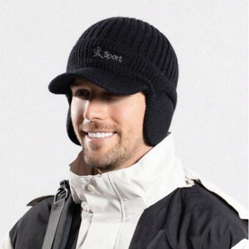 Bonnet à visière noir de sport d'extérieur Lake Placid avec cache-oreilles sur la tête d'un homme souriant habillé chaudement d'un anorak 