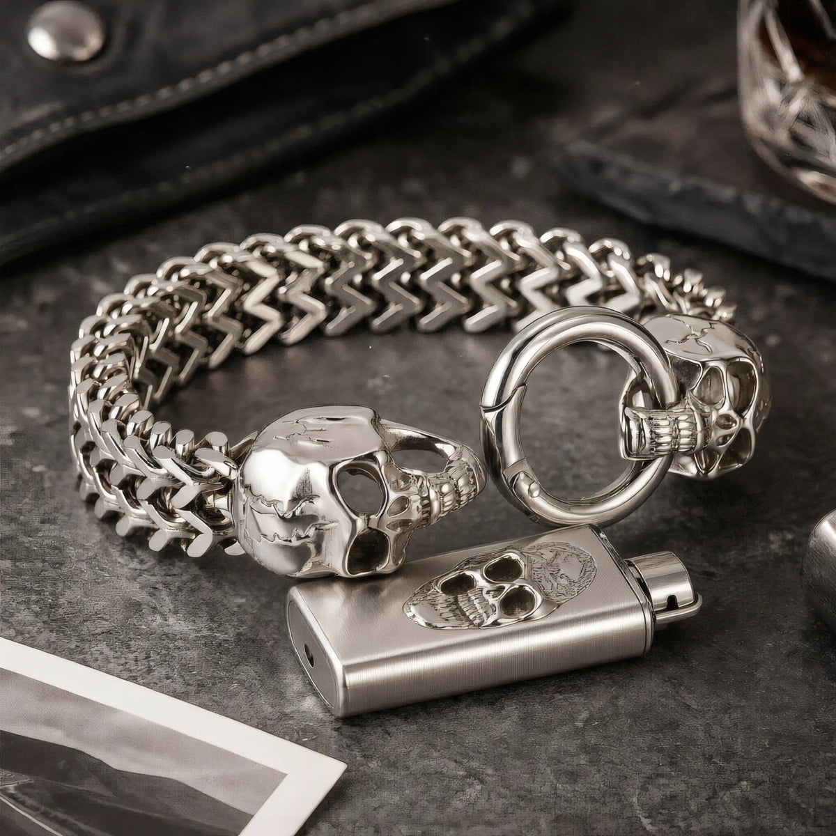 Bracelet acier en maille double renard avec têtes de mort Calavera et briquet posé dans un univers rock.