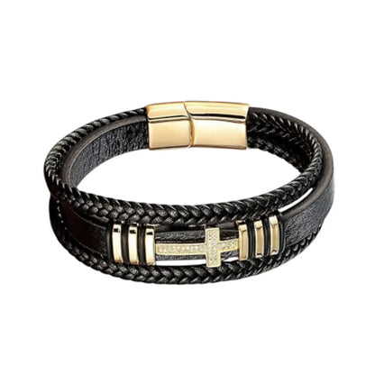 Gros plan. L'éclat du bracelet Aegis est accentué par la Croix Latine et les motifs dorés polis, contrastant avec le cuir noir.