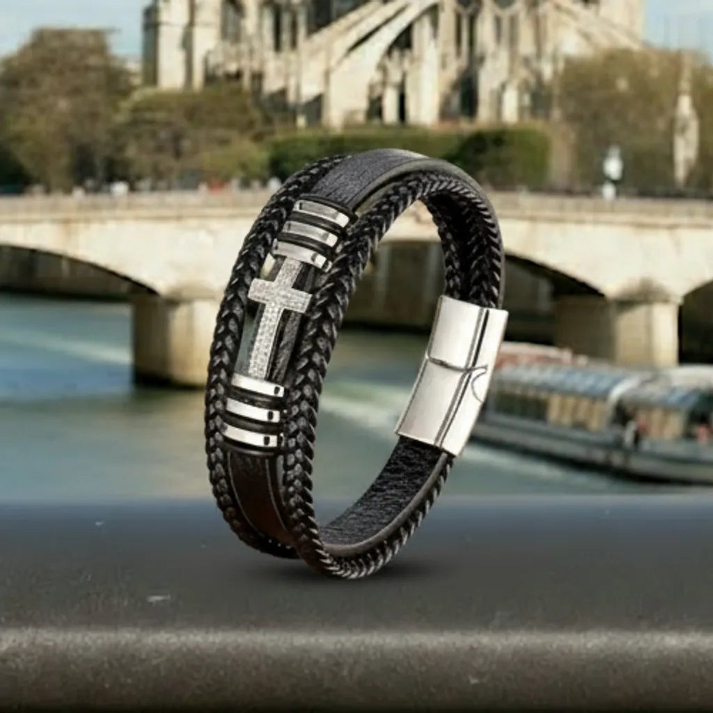 Force et structure. Le bracelet Aegis cuir noir multi-rangs est mis en scène contre une rambarde métallique, évoquant une armure moderne.
