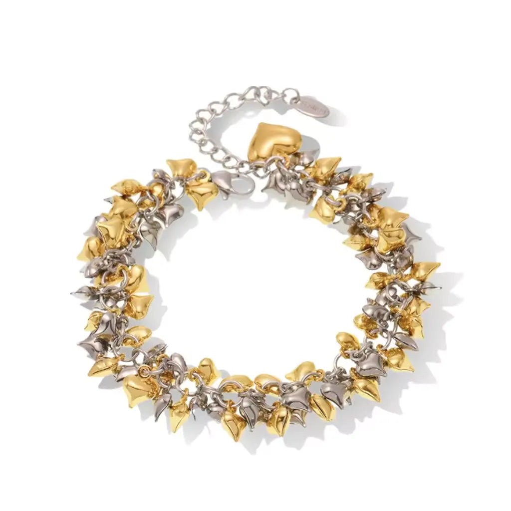 Bracelet bicolore en acier inoxydable doré et argenté Amorina, breloques en forme de cœur, rendu studio lumineux et premium.