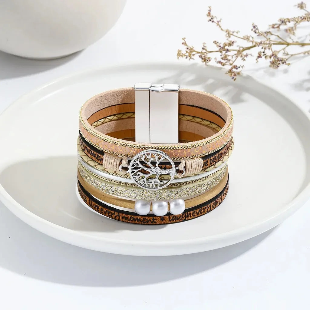 Bracelet arbre de vie multi-rangs en cuir microfibre végan beige avec fermoir magnétique, posé sur assiette blanche décorative.