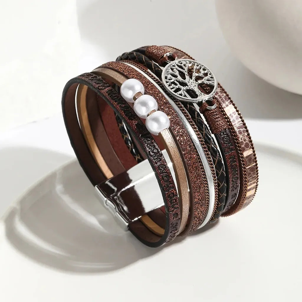 Bracelet arbre de vie multi-rangs en cuir microfibre marron avec charm argenté, vue en biais sur fond clair.