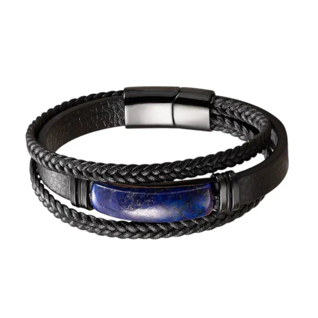 Composition frontale du Bracelet Astra dévoilant l'équilibre entre ses lanières en cuir noir tressé et sa bande centrale texturée, où trône un lapis-lazuli oblong escorté de quatre bagues d'acier noir sur un fond blanc minimaliste.