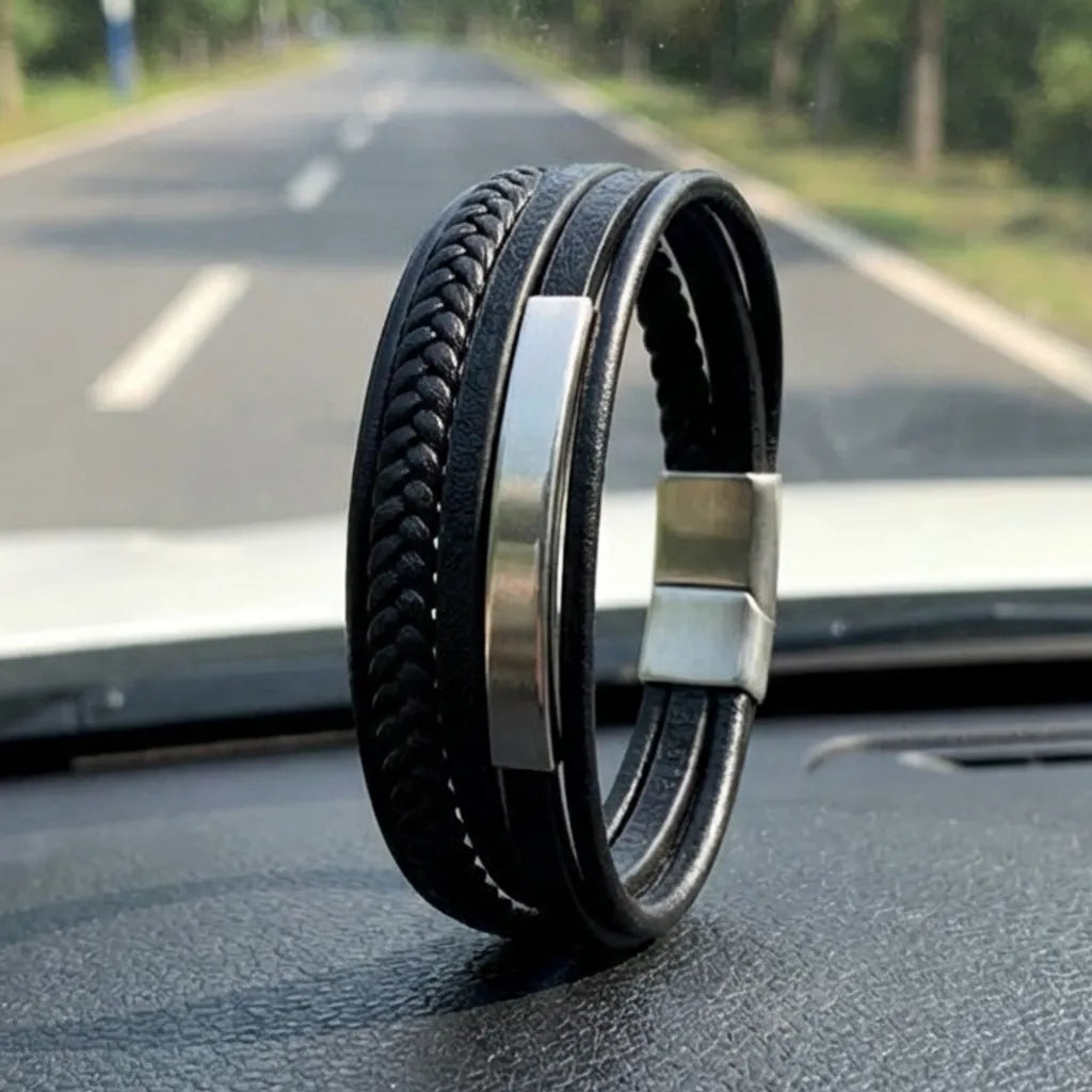 Ambiance Route. Le bracelet Axis cuir souple noir, dressé sur le tableau de bord. Le tube rectangulaire en acier et le multi-rangs de cuir rythment le voyage.