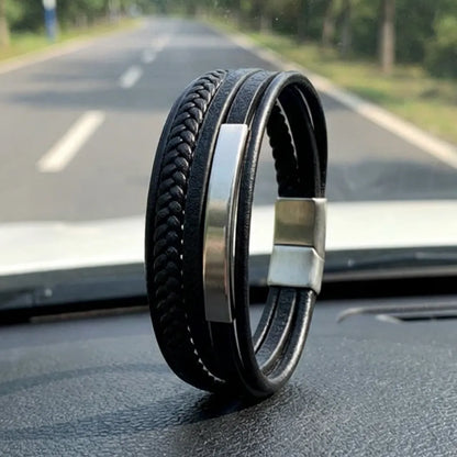 Ambiance Route. Le bracelet Axis cuir souple noir, dressé sur le tableau de bord. Le tube rectangulaire en acier et le multi-rangs de cuir rythment le voyage.