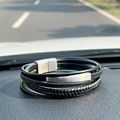 Détail de l'élégance. Gros plan sur le bracelet Axis cuir souple noir, mettant en lumière le tube rectangulaire et le fermoir magnétique en acier poli sur le tableau de bord.