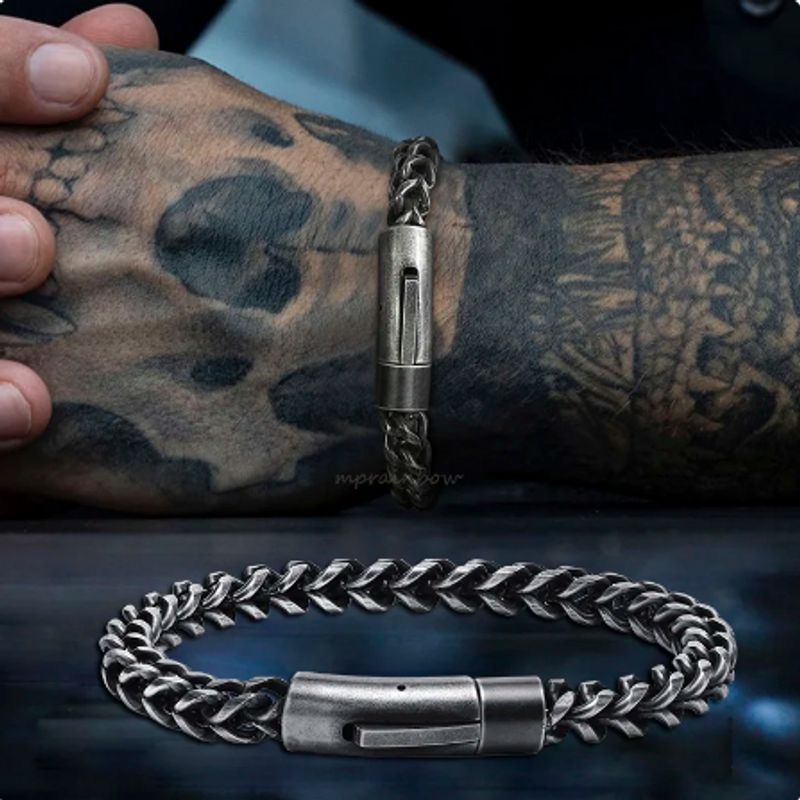 Vue sur deux prises du bracelet à maillons cubain de 6 millimètres en acier inoxydable - présentation sur un poignet d'homme viril tatoué - catégorie chaine gourmette - fermoir rapide, robuste sécurisé - couleur de l'acier, argent vieilli