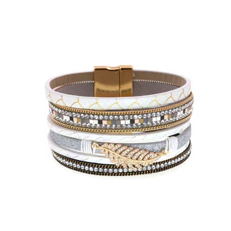 Bracelet bohème chic, wrap multilanière en cuir PU imprimer avec breloque feuille de fougère dorée et ornée de strass en cristal, son fermoir magnétique est de couleur or. Coloris cuir blanc.