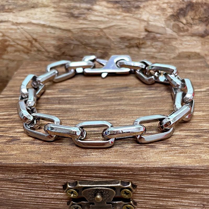 Bracelet chaîne d'ancre à maillons rectangulaires en acier inoxydable posé sur une boite en bois - coloris argent
