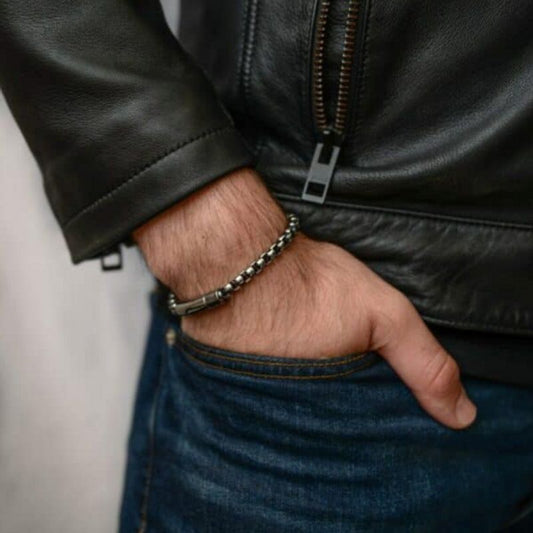 Bracelet avec chaîne à maillons vénitiens de 6 mm en acier inoxydable, son fermoir et un tube clip à ressort - présenté sur poignet d'homme la main dans la poche avant de son blue jean - coloris acier argent