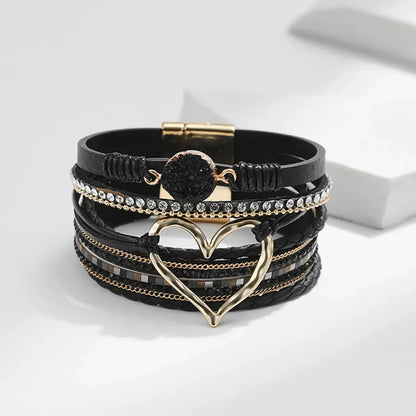 Vue frontale du bracelet Cœur de Lune Vagabonde noir. Le cœur ajouré doré et la pierre résine à l'effet druse sont au centre de l'attention, sur un fond épuré.