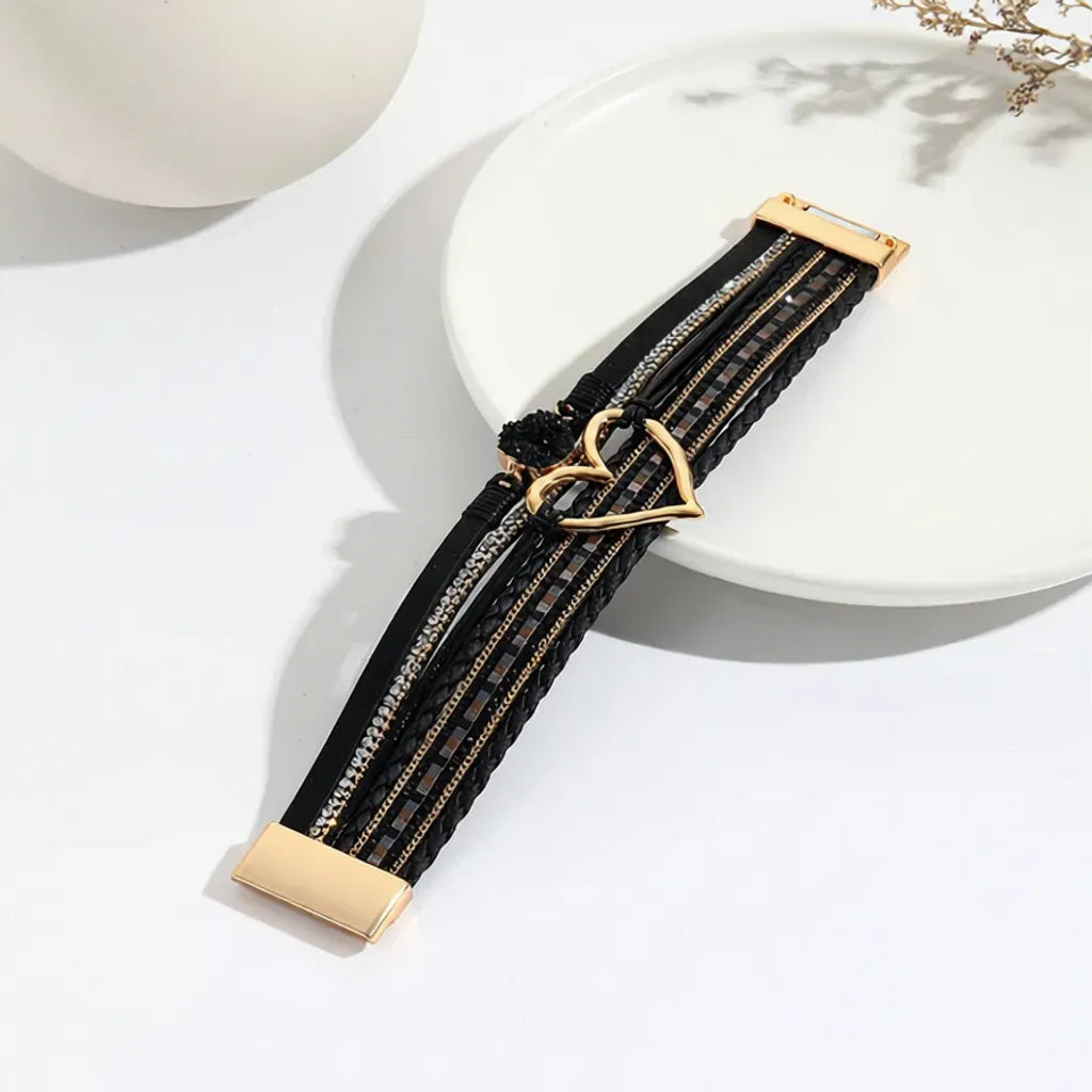 Bracelet Cœur de Lune Vagabonde noir ouvert à plat sur une assiette. Il expose l'harmonie des multi-rangs et le cœur central ajouré.