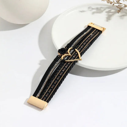 Bracelet Cœur de Lune Vagabonde noir ouvert à plat sur une assiette. Il expose l'harmonie des multi-rangs et le cœur central ajouré.