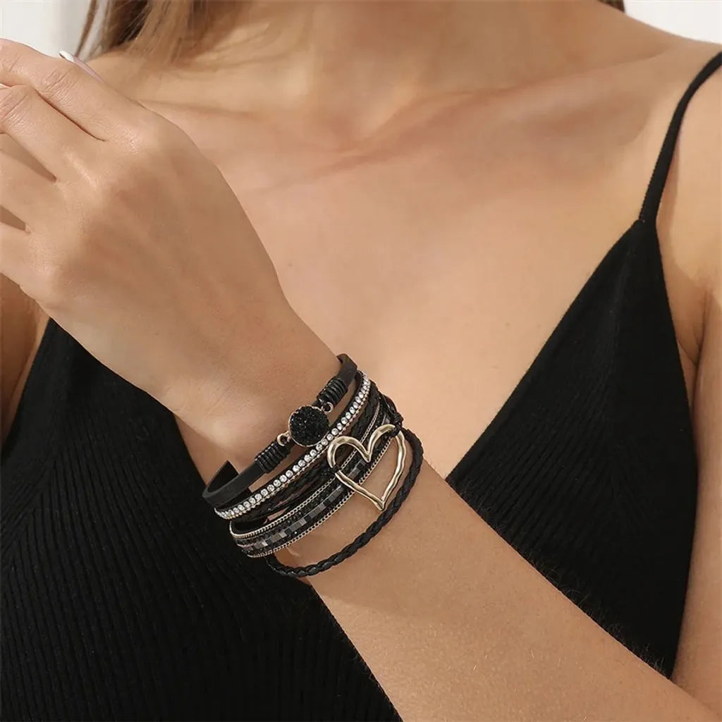 Le bracelet Cœur de Lune Vagabonde noir porté avec une tenue décontractée chic, un top noir simple rehaussant son design.
