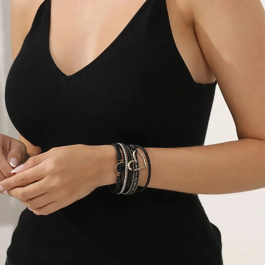 Le bracelet Cœur de Lune Vagabonde noir, assorti à une tenue d'été légère. Le cœur ajouré capte la lumière.