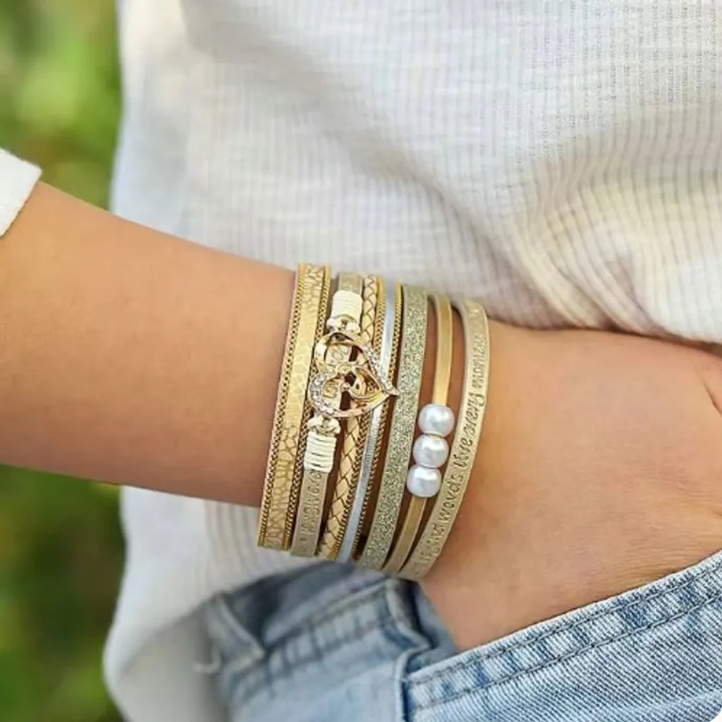 Bracelet cœur mère et enfant multi-rangs beige, cuir microfibre végan, perles décoratives, porté sur jean et pull clair.