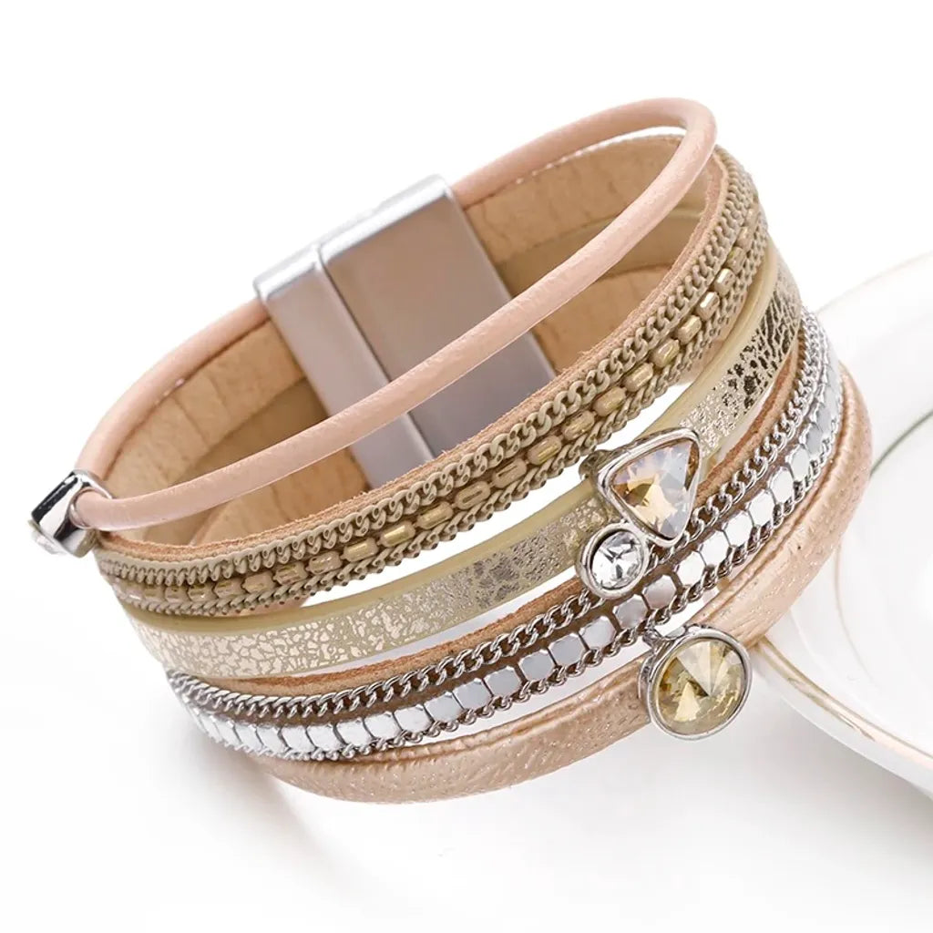 Bracelet Cristal de lumière multi-rangs. Gros plan sur ses charms géométriques et le cuir microfibre beige.