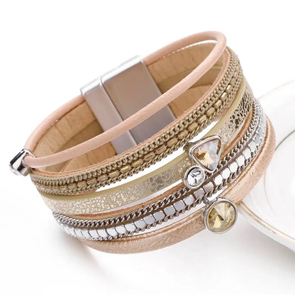 Bracelet Cristal de lumière multi-rangs. Gros plan sur ses charms géométriques et le cuir microfibre beige.