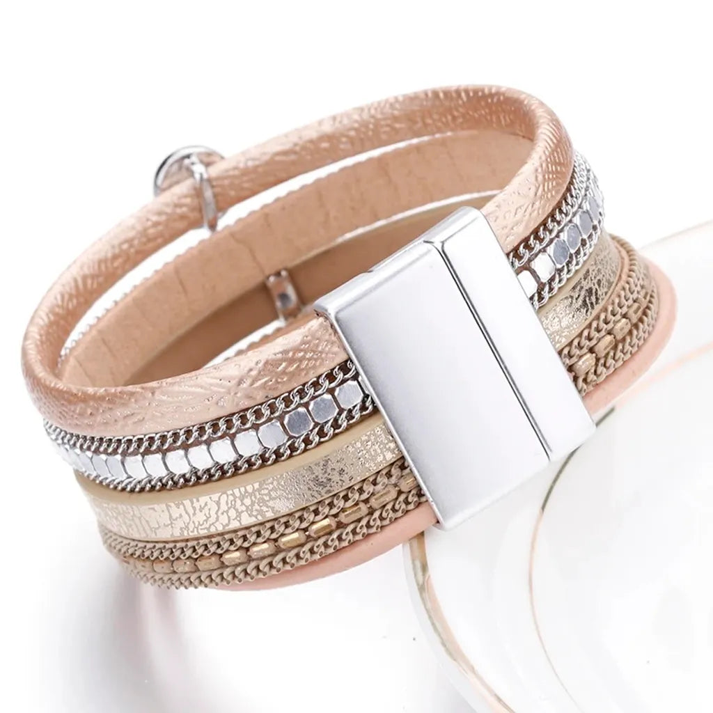 Vue latérale du bracelet beige. Le fermoir magnétique argenté et la superposition de rangs sont mis en évidence.