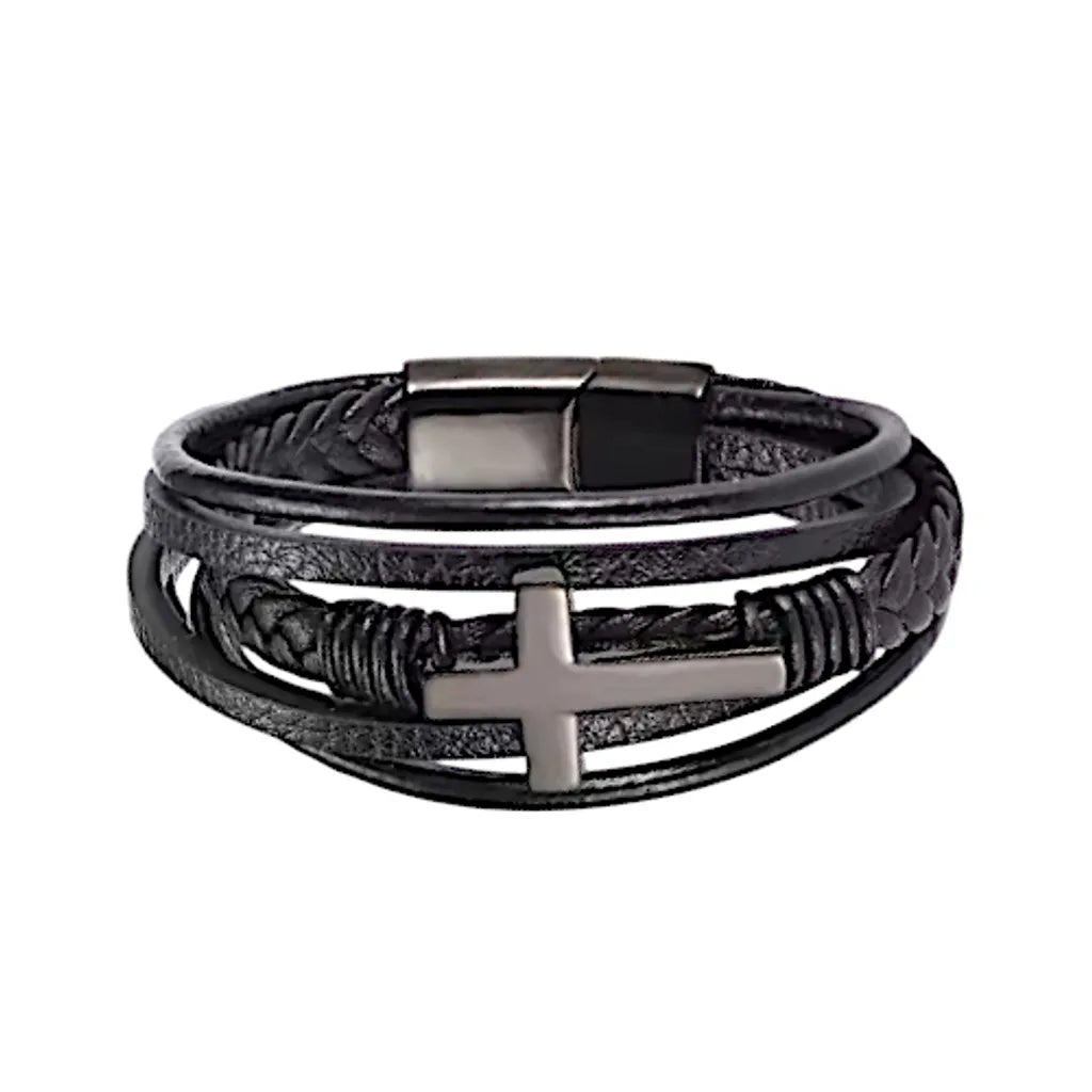 Gros plan sur le bracelet en cuir noir avec sa croix latine et son fermoir noirs en acier inoxydable, sur fond blanc.