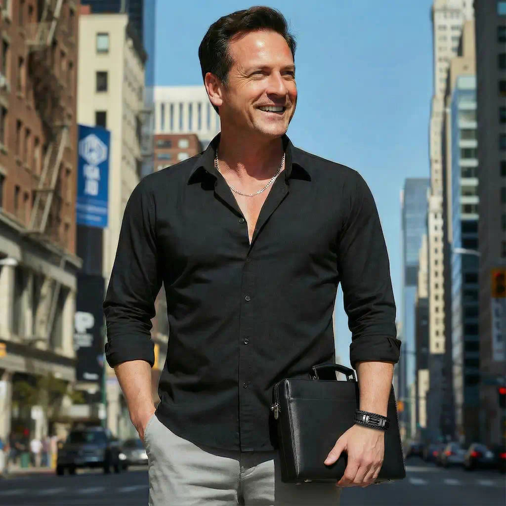 Plan poitrine dynamique d'un homme confiant, le bracelet Éclipse en cuir et agate noire magnifiant son poignet, incarnant une esthétique chic et décontractée au cœur de la vibrante scène urbaine.