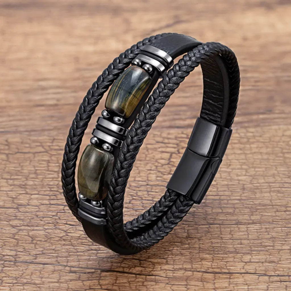 Bracelet multirang en cuir noir avec pierre œil de tigre bleue, idéal pour homme. L’association de la pierre bleue et du cuir tressé apporte une touche de modernité à ce bijou masculin.