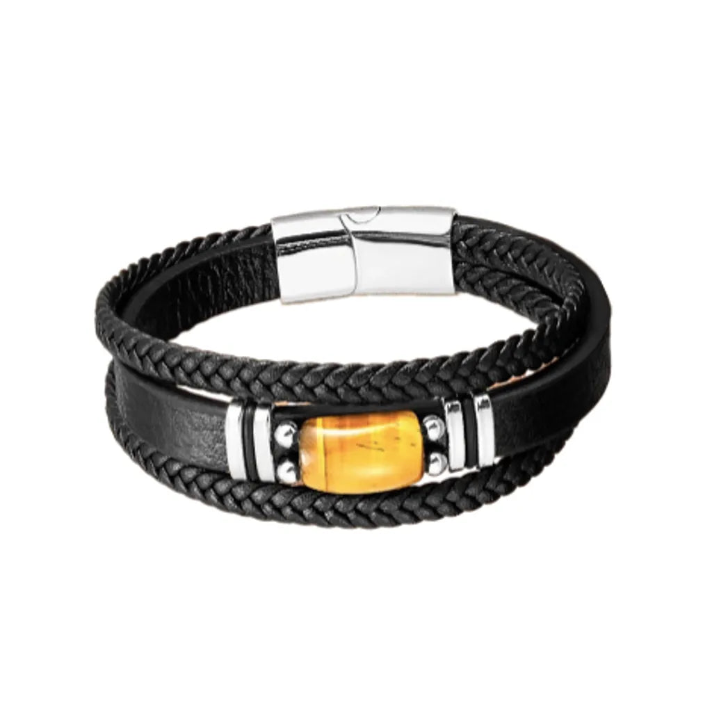 Bracelet pour homme en cuir noir avec double tresse et lanière en cuir lisse, orné d'une pierre œil de tigre jaune rectangulaire en son centre. Fermoir magnétique, argenté, robuste et design élégant, parfait pour un style masculin et raffiné. Accessoire idéal pour ajouter une touche naturelle et sophistiquée à toute tenue.