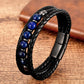 Bracelet en cuir noir tressé, agrémenté de perles bleues en lapis-lazuli, présenté sur un fond boisé chaleureux, soulignant le contraste entre la profondeur du bleu et le cuir sombre.