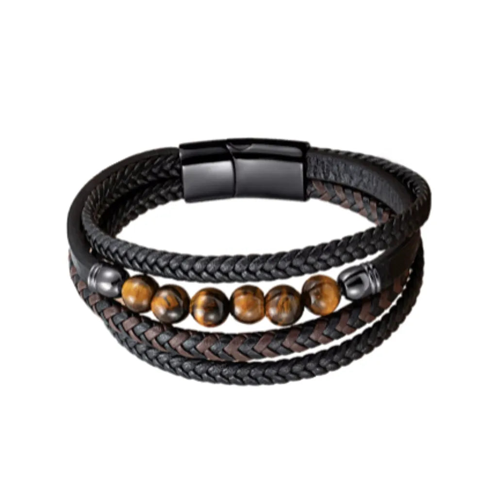 Bracelet en cuir tressé noir et marron, décoré de perles en œil de tigre jaune brillant, avec un fermoir noir élégant. Le design sophistiqué et les couleurs chaudes des perles s'harmonisent avec le cuir tressé, créant un bijou masculin parfait pour un look décontracté ou chic.