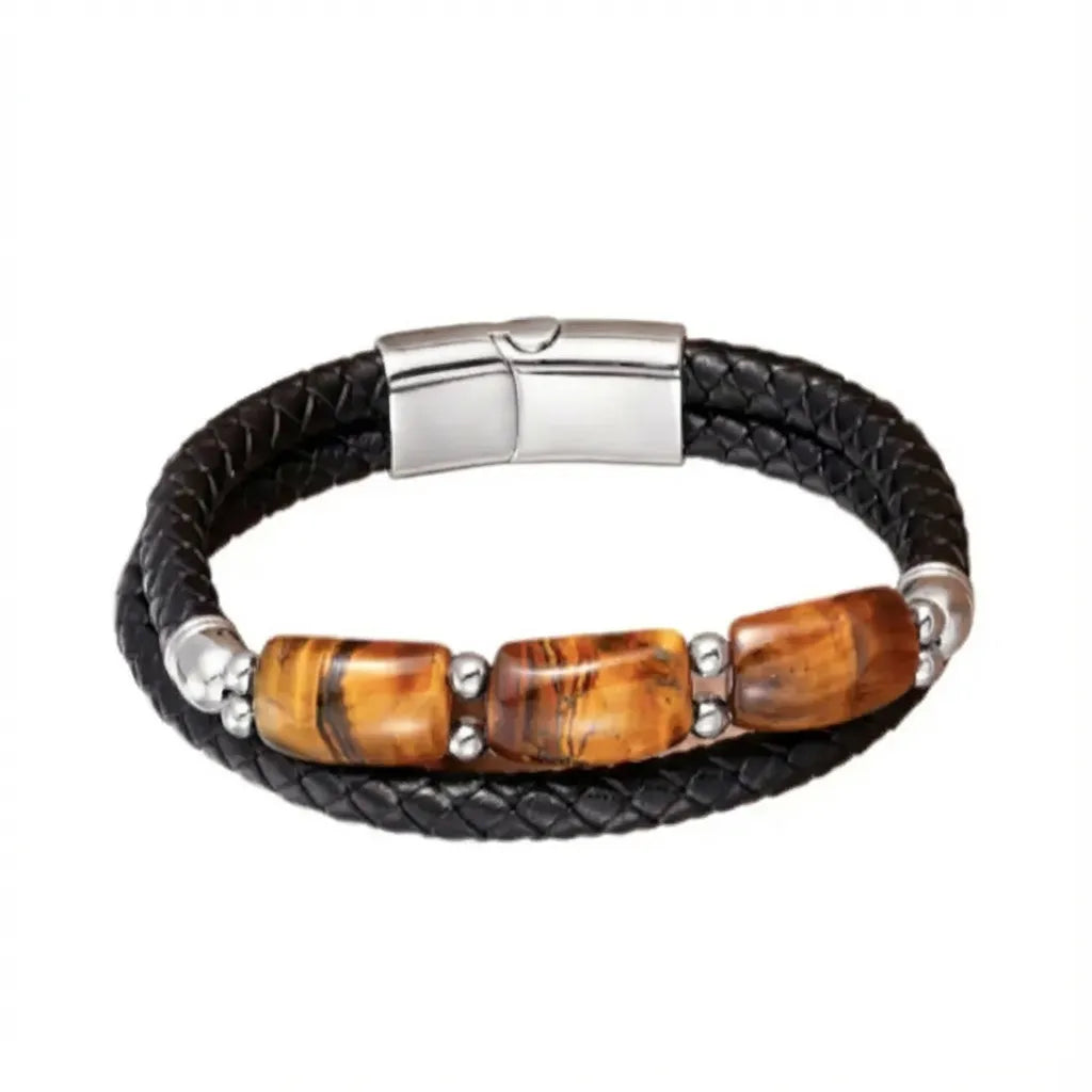 Bracelet en cuir noir tressé agrémenté de trois pierres œil de tigre jaune rectangulaires, montées avec des éléments en acier poli. Ce bijou incarne l'élégance et la puissance, idéal pour réaliser un look masculin raffiné.
