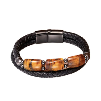 Bracelet en cuir noir tressé agrémenté de trois pierres œil de tigre jaune rectangulaires, montées avec des éléments en acier noir. Ce bijou incarne l'élégance et la puissance des matériaux naturels, idéal pour compléter un look masculin raffiné.