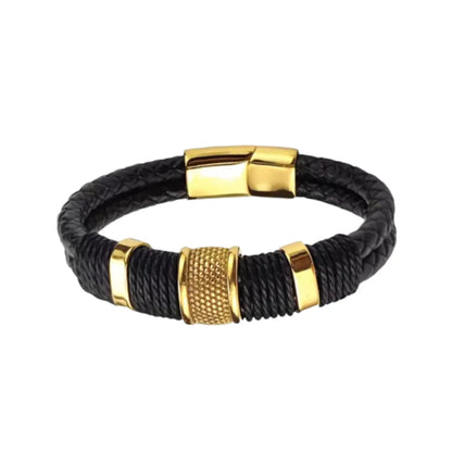 Vue de face. La pièce maîtresse Cylindre Pointillé doré rayonne entre les deux lanières de cuir noir structuré, soulignant la symétrie du design.