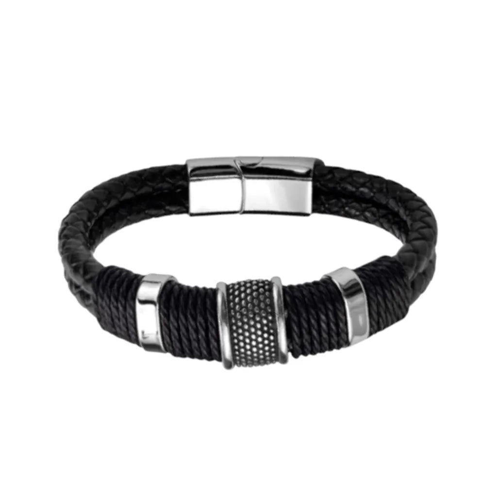 Packshot. Le bracelet Cylindre Pointillé en finition argentée poli, mis en évidence par le contraste du double cuir noir tressé sur fond blanc épuré.