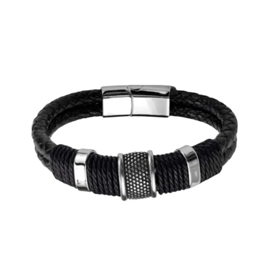 Packshot. Le bracelet Cylindre Pointillé en finition argentée poli, mis en évidence par le contraste du double cuir noir tressé sur fond blanc épuré.