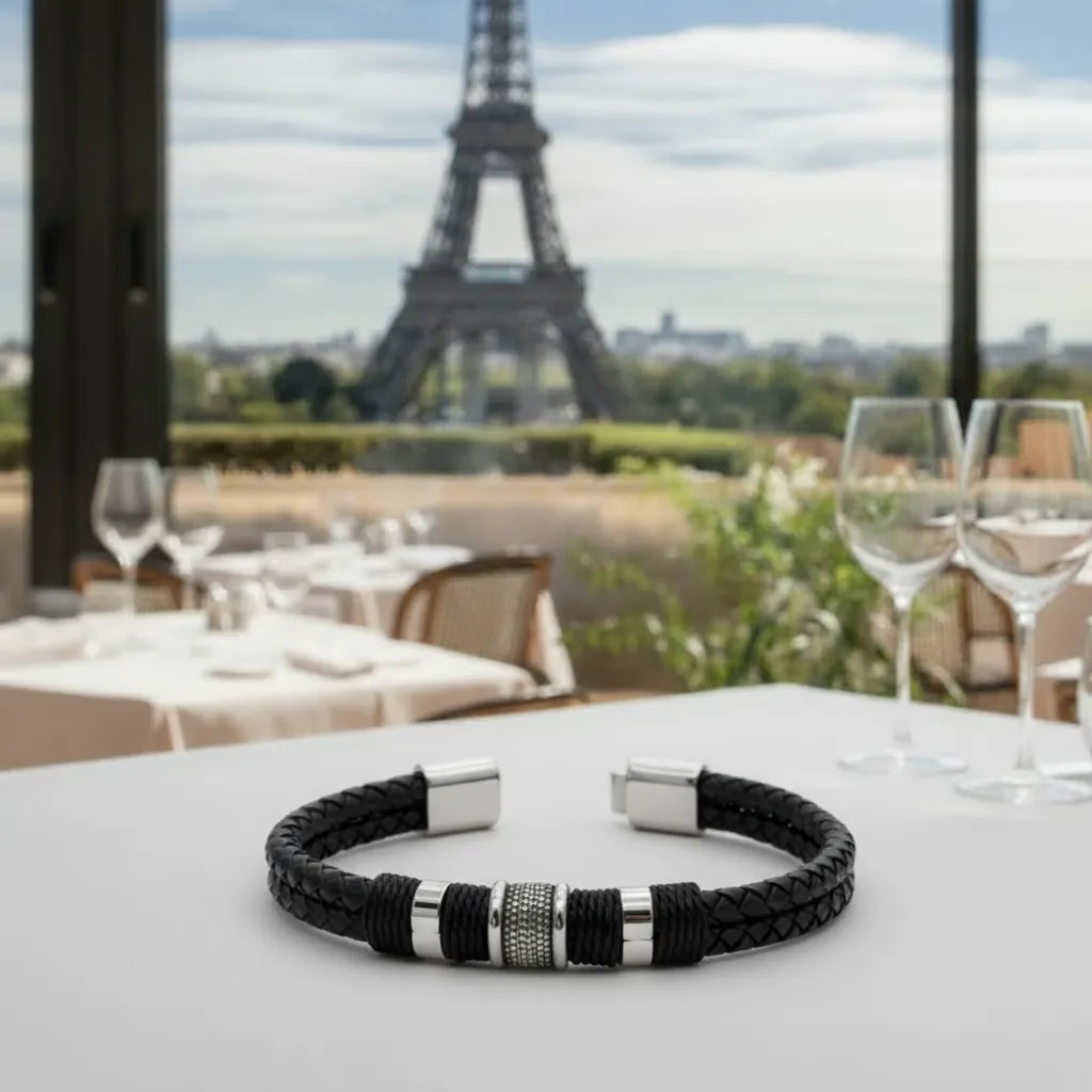 Vue détaillée du bracelet en cuir noir posé à plat, le fermoir magnétique ouvert révèle les doubles lanières tressées.