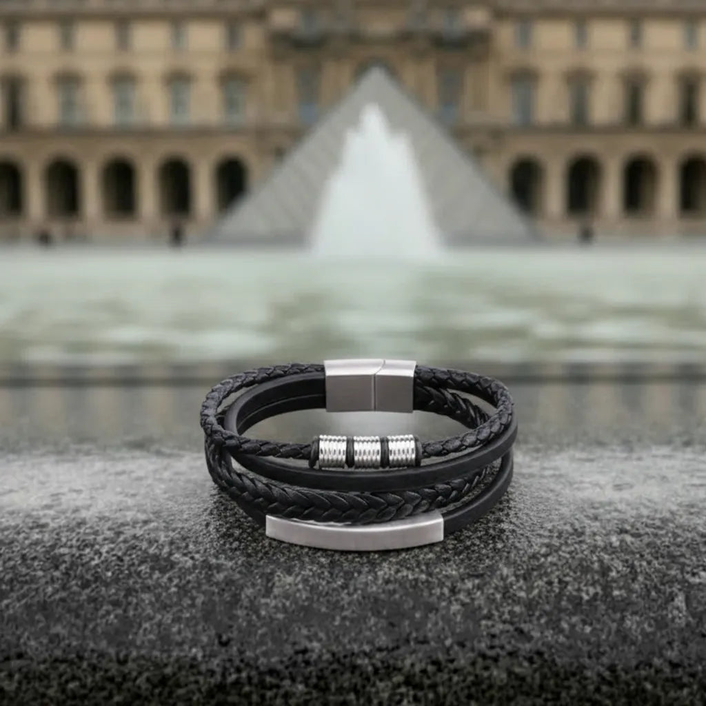 Vue de face. La surface plane et le cuir tressé du bracelet Equinox contrastent avec la pureté géométrique du musée du Louvre.