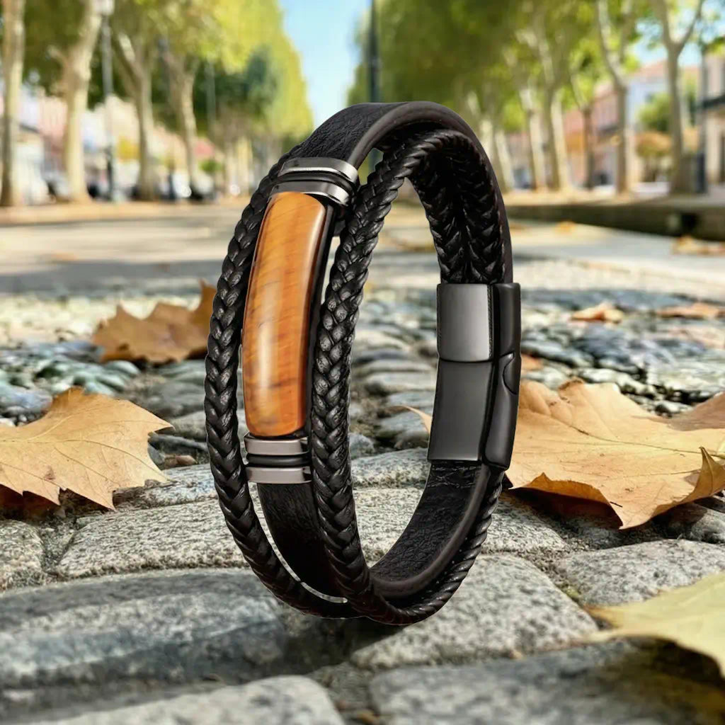 Le bracelet Fauve s'érige avec distinction sur un sentier pavé, capturant la lumière entre ses lanières tressées et son œil de tigre central sous une allée de platanes majestueux.