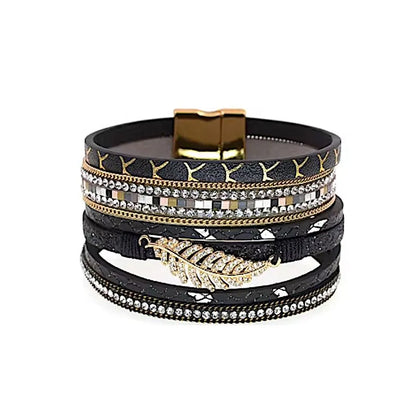 Bracelet Fougère multi-rangs noir en cuir microfibre avec fermoir doré, feuille dorée centrale et décor de strass scintillants.