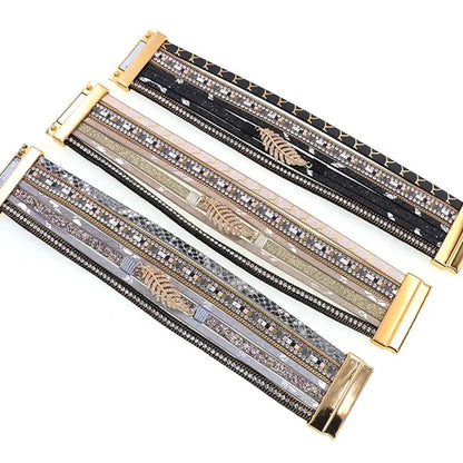 Trois bracelets Fougère multi-rangs en cuir microfibre alignés, fermoir magnétique doré, motif feuille et rangs strass cristal.