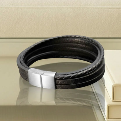 Gros plan technique. L'arrière du bracelet Fusion multi-rangs cuir souple noir, mettant en avant le fermoir magnétique plat en acier argenté. L'élément de sécurité discret de l'assemblage.