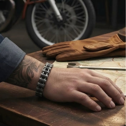 Bracelet Kross chaîne moto acier rétro porté main posée table largeur treize millimètres.