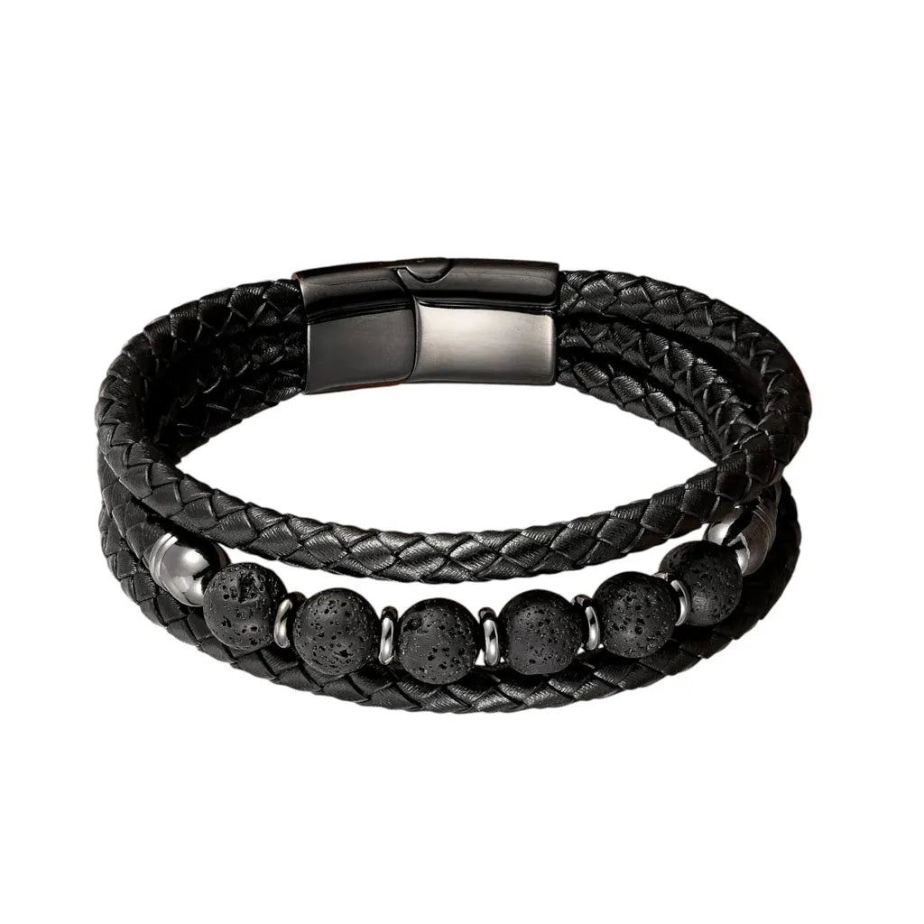 Vue frontale détaillée du bracelet Vulcan révélant le contraste entre la porosité brute des perles de pierre de lave et la texture mate du cuir noir tressé, avec son fermoir magnétique en acier inoxydable noir.