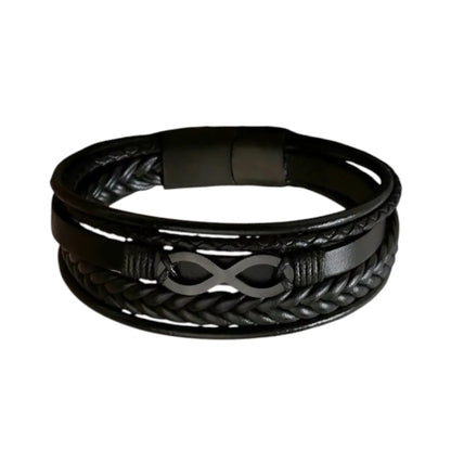 Plan large du bracelet Infini noir. Le cuir structuré noir multi-rangs met en valeur le fermoir magnétique en acier inoxydable noir sur fond blanc.